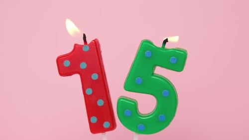 Fifteen Years Anniversary Video Banner with Burning Spotted Red and Green Number Fifteen Candle on