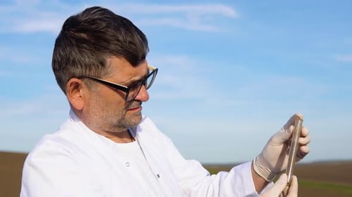 Senior Scientist Studying Sample of Soil in Field Soil Sampling for Chemical Analysis and Ph Test