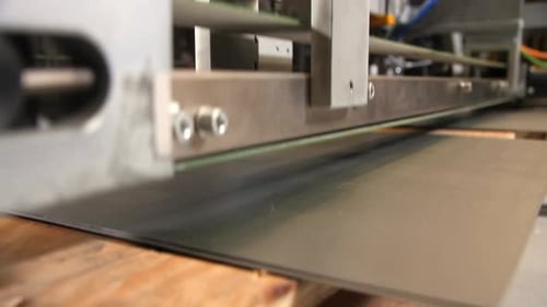 Manipulator mit Magneten nimmt Blech in Werkstatt