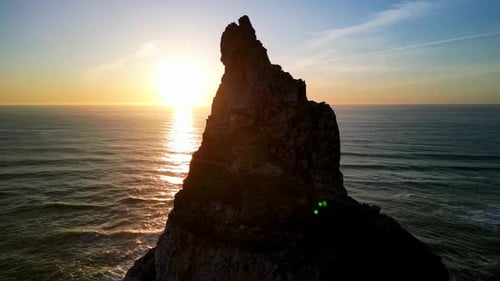 Witness the Majestic Ocean Sunset Casting Its Colors Over a Rocky Pinnacle a Stunning View