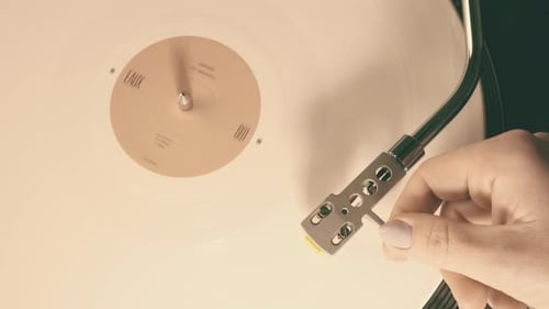 Vinyl Retro record on DJ turntable record player close up. Girl's hand puts, lowers the stylus