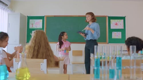 Adorable student learn with teacher in classroom at elementary school.