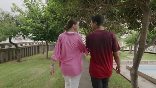 Shot From Backwards of Young Teen Caucasian Couple Walking in Park