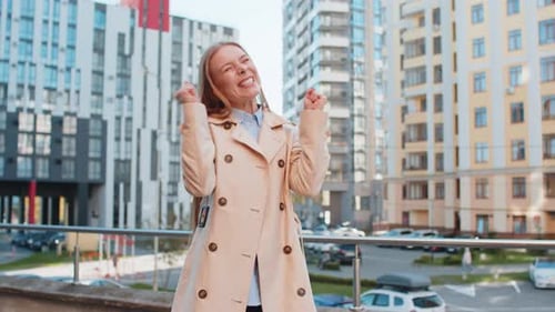 Excited Woman Looking Surprised Clenching Fists Shocked By Sudden Victory Standing on City Street