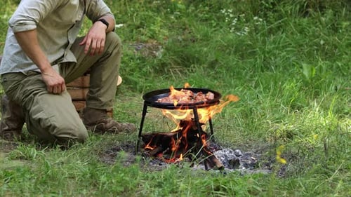 Hombre cocinando carne sobre una fogata