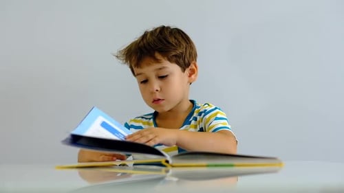 Boy Reading a Colorful Book Indoors