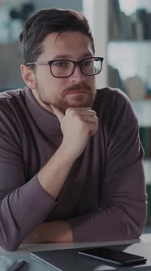 Man Thinking Thoughtfully at Table Indoors