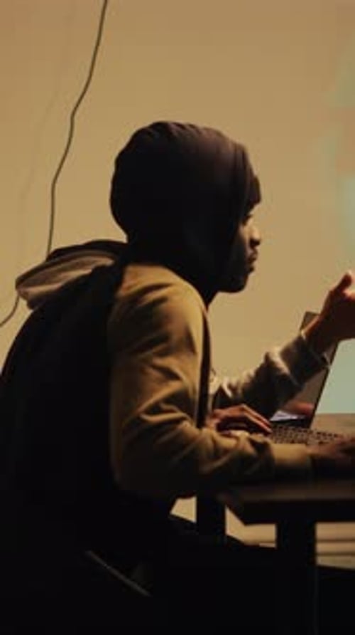 Hooded Figures Coding at Dark Computer Workplace