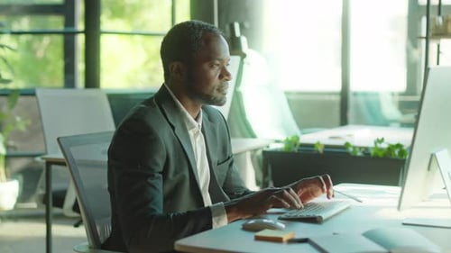 Shooting of Male Office Worker Sitting at Computer Typing on Keyboard Portrait of Intelligent