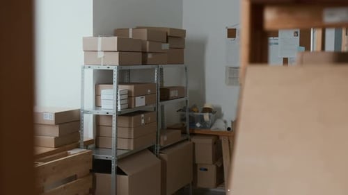 Salle de rangement remplie de boîtes en carton, d'étagères en métal et de tableau d'affichage
