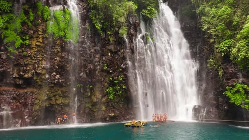 Tropical Waterfall with People on Bamboo Raft