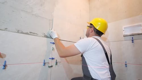 Construction Worker Tiling Walls in Indoor Space