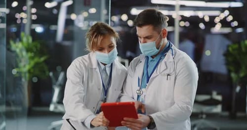 Doctors Reviewing Data on Tablet at Hospital