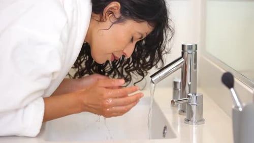 Mujer lavándose la cara a cámara lenta