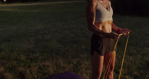 Athletic Woman Exercising With Resistance Bands in Nature