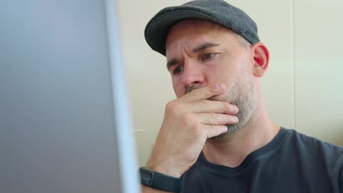 Serious Focused Man Looking At Screen Of His Laptop - close up