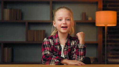 Blond-Haired Girl Speaking at Desk
