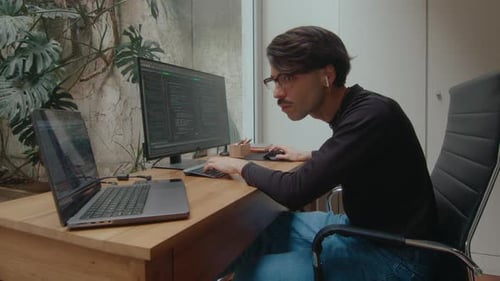 Programmer Working on PC and Laptop and Typing Computer Code