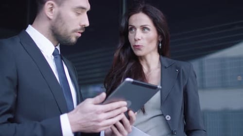 Business Colleagues Discussing Data on a Tablet Device