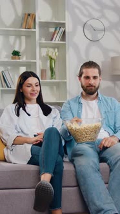 Portrait of Tired Parents Mother and Father Sitting on Sofa Front Tv Touching Head Active Noisy Kids