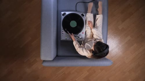 Child Listens to Music on Vinyl Record Player