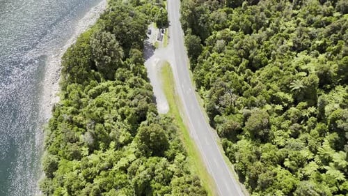Panorama aéreo do rio sereno que se curva através de uma paisagem florestal exuberante com viagens rodoviárias sinuosas