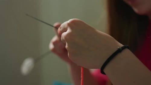 Woman Knitting with Orange Yarn Indoors