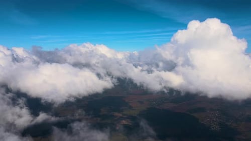Aerial View From Airplane Window at High Altitude of Earth Covered with Puffy Cumulus Clouds Forming