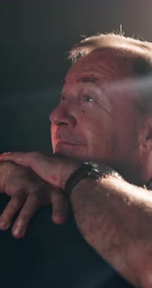 Smile, cinema and senior man watching movie for premiere entertainment with bright light