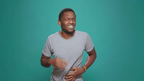 Man Holding Stomach in Pain on Green Background