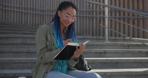 Student Writing in Notebook on Concrete Steps