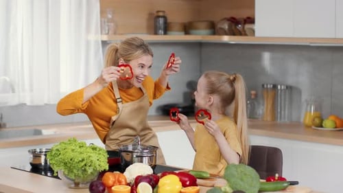 Young Happy Mother Playing with Her Little Daughter Wearing Pepper Glasses Laughing Together at