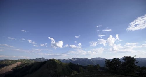 Timelapse of clouds moving in over mountain range at sunset.