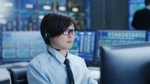 Im Network Operations Center tätigt Trader mit einem Headset einen persönlichen Kundenanruf. Er ist umzingelt