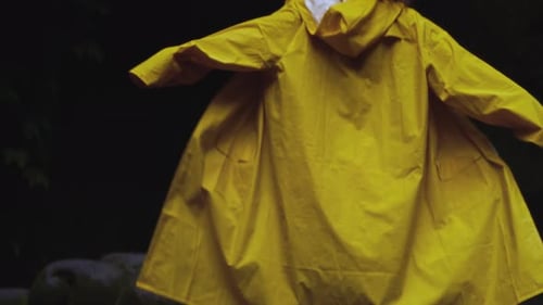 Young Adult in Raincoat Enjoys Forest Shower