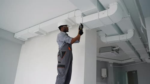 Man Working on Ventilation System Installation