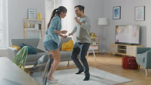 Couple having fun dancing in living room together