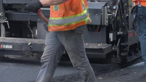 Straßenbauarbeiten Neue Asphaltstraße in einem Vorort, Nahaufnahme des Asphaltfertigers