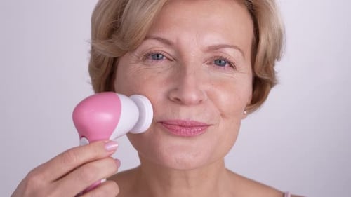 Woman Cleansing Face with Beauty Device Close-Up