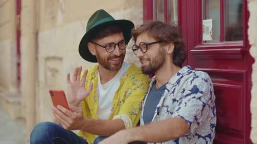 Two Friends Laughing at Smartphone on City Street