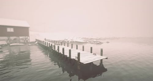 Snowy Dock se estende até águas nebulosas perto de uma cabana tranquila no inverno