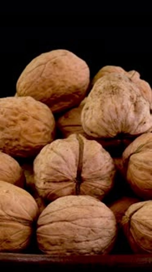 Many Whole Walnuts in Peel in Dish As Healthy Eating Example Rotate