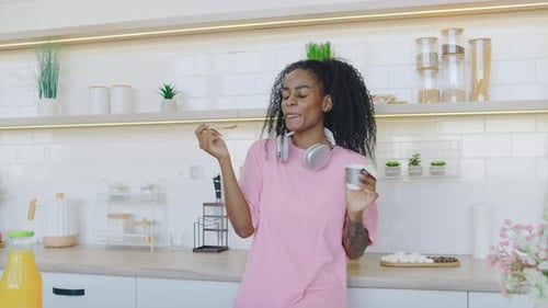 Woman Eating Yogurt in Bright Modern Kitchen