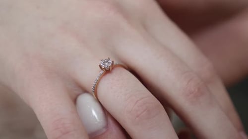107er Jahre. Freundin untersucht den Ehering am Finger der Braut.