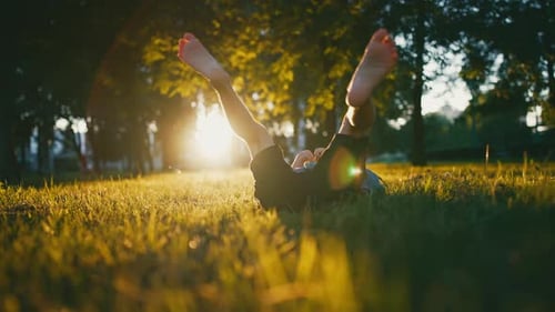 Bare Feet of a Child in the Green Grass of a Sunny Park in Summer