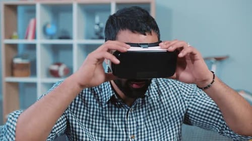 Man Taking Off VR Headset, Smiling in Living Room