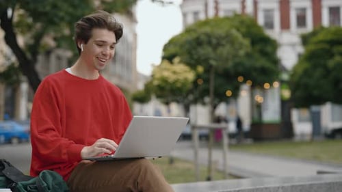 Young Adult Video Calling On Laptop Outdoors