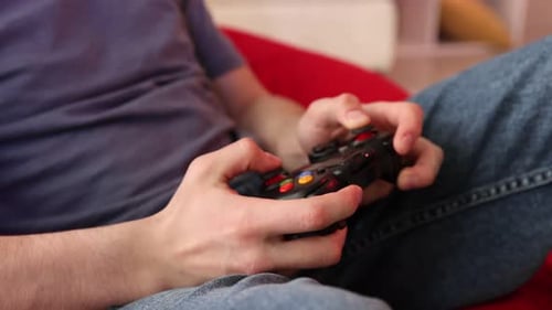Teenage boy playing video game at home, closeup