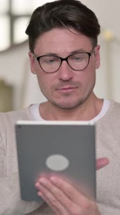 Man Using a Tablet Device at Home