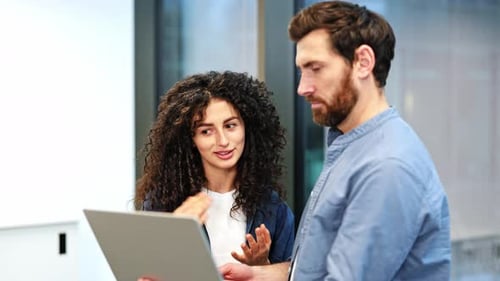 Business Colleagues Collaborating on a Laptop in a Modern Office